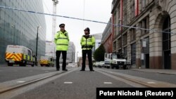 Police stand in the vicinity of Manchester Arena where 22 died in a bomb attack on May 22. 