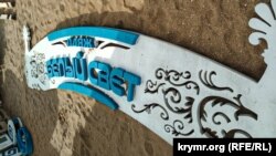 Вывеска пляжа «Белый свет» на песке в поселке Береговое под Феодосией, июль 2020 года