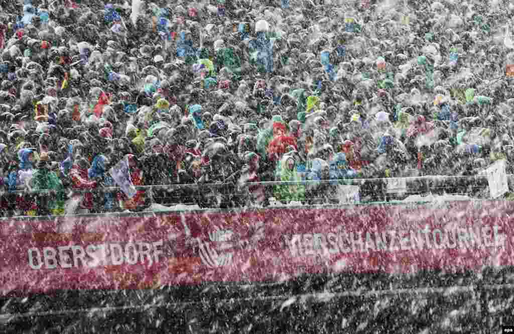 Visitors weather the driving snow during the 63rd Four Hills ski-jumping tournament in Oberstdorf, Germany. (epa/Fredrik von Erichsen)