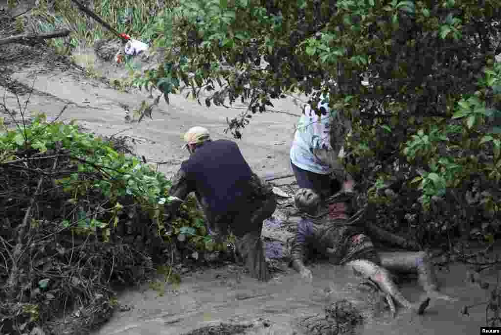 People try to help a man during heavy flooding in the Bulgarian city of Varna on June 19, which killed at least 12 people. (Reuters)