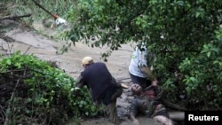People try to help a man in distress during heavy flooding in the city of Varna on June 19.