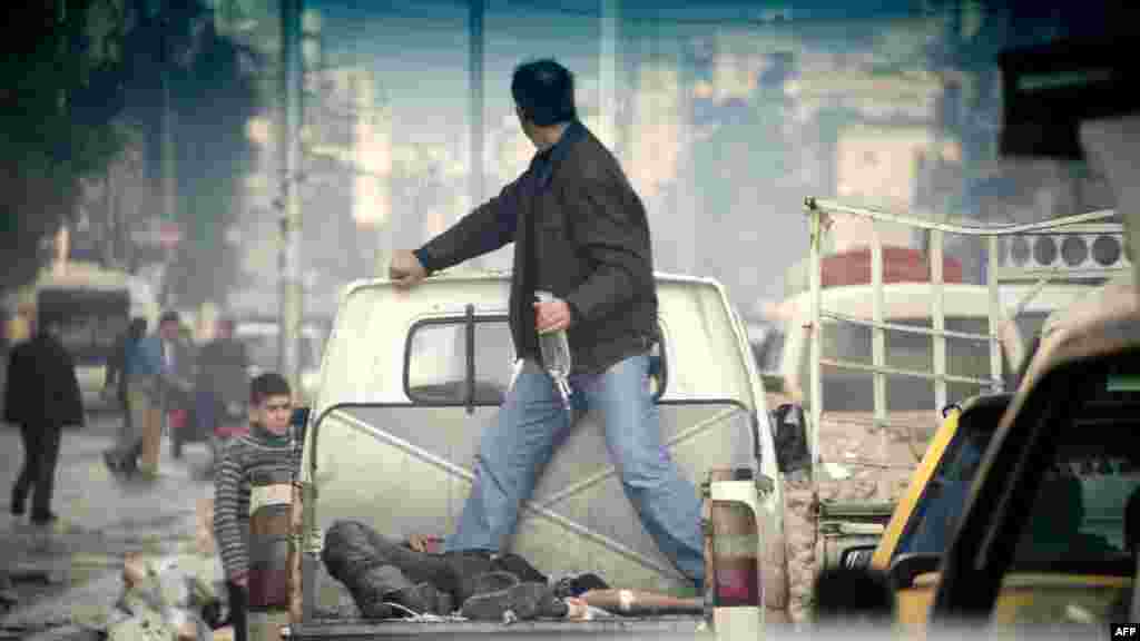 A wounded rebel fighter lies in the back of a pickup truck making its way to a hospital through traffic in the northern Syrian city Aleppo. (AFP/Odd Anderson)