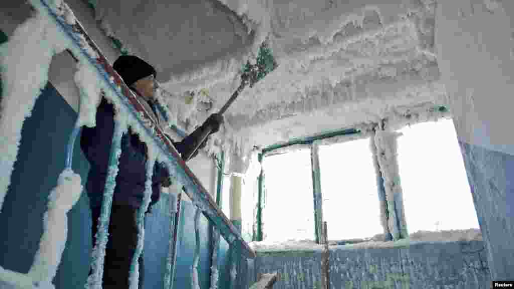A man removes ice in a stairway caused by a broken sewage line in an apartment block in Karaganda, Kazakhstan. Temperatures dropped to minus 59 Celsius in the eastern region of the country. (Reuters/Valery Kaliyev)