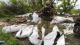Украинский военнослужащий во время эксгумации убитых военных России на их прежних позициях вблизи села Мала Рогань в окрестностях Харькова
