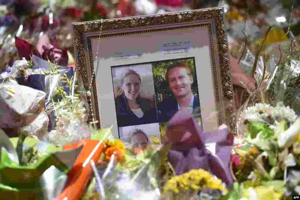 Photos showing Katrina Dawson (left) and Tori Johnson (right) sit among the floral tributes left outside the Lindt cafe in Sydney&#39;s Martin Place, one week after a siege at the cafe that saw hostages Dawson and Johnson killed, along with the gunman.