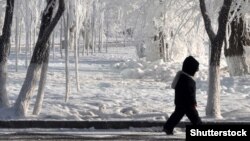 Қыстыгүні көшеде кетіп бара жатқан бала. Көрнекі сурет.