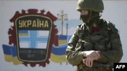 A soldier -- one of the so-called "polite people" -- stands guard near a Ukrainian border guards base not far from the Crimean village of Perevalne near Simferopol on March 3.