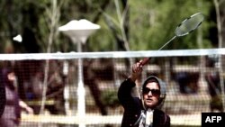 A woman plays badminton in a Tehran park.