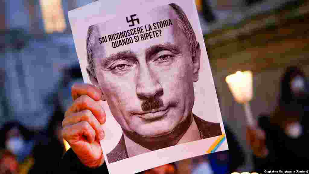 A protester holds a picture of Russian President Vladimir Putin in which he resembles Nazi dictator Adolf Hitler in Rome on February 25.