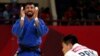 Judo - 2018 Asian Games - Men’s -73kg, Bronze Medal Match - JCC Plenary Hall, Jakarta, Indonesia - August 30, 2018 - Mohammad Mohammadi Barimanlou of Iran celebrates his win as Kim Chol Gwang of North Korea looks dejected.