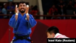 Mohammad Mohammadi Barimanlou of Iran celebrates his win as Kim Chol Gwang of North Korea looks dejected. Asia Games, August 30, 2018