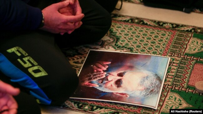 یک نمازگزار لبنانی پوستر قاسم سلیمانی را در مراسم نمازجمعه مقابل خود قرار داده است.