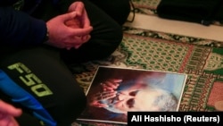 A man prays next to a picture of late Iranian Major-General Qassem Soleimani, head of the elite Quds Force, inside a mosque in Ghazieh, January 3, 2020