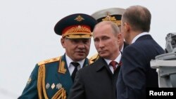 Russian President Vladimir Putin (center) and Defense Minister Sergei Shoigu (left) review the Russian fleet in Sevastopol on May 9.