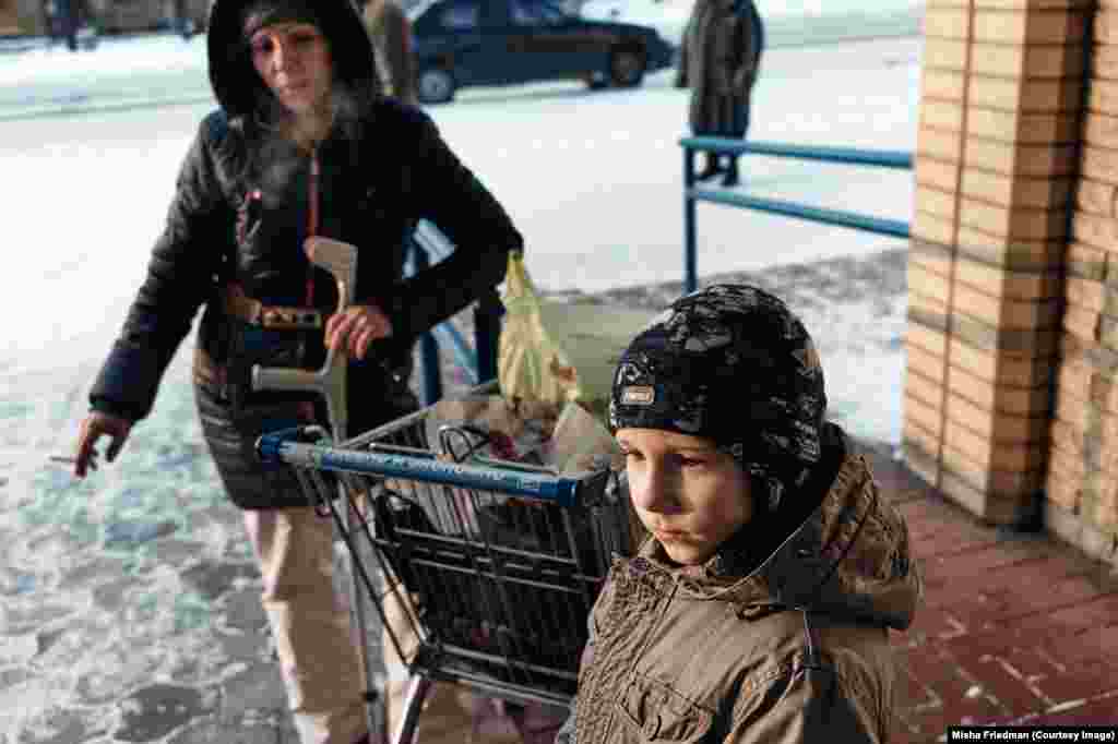 Alla with her son after getting groceries paid for by an NGO that assists internally displaced people with drug problems. The HIV sufferer fled her home just outside of Donetsk during fighting and is now living with her son in Kramatorsk. 