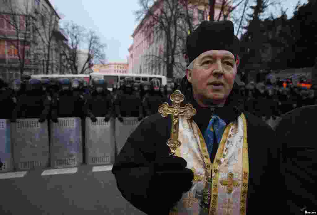 An Orthodox priest walks past a police cordon near Independence Square in Kyiv. (Reuters/Stoyan Nenov)