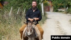 Russian businessman German Sterligov rides a donkey in Nagorno-Karabakh, 7Jul2015.