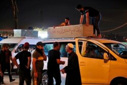 Mourners load the coffin of Saleh Ahmed, 27, a protester killed in an anti-government demonstration, during his funeral in Najaf, Iraq, Monday, Oct. 28, 2019.