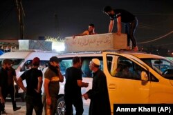 Mourners load the coffin of Saleh Ahmed, 27, a protester killed in an anti-government demonstration, during his funeral in Najaf, Iraq, Monday, Oct. 28, 2019.