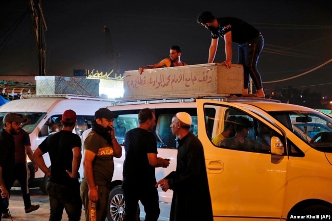 Mourners load the coffin of Saleh Ahmed, 27, a protester killed in an anti-government demonstration, during his funeral in Najaf, Iraq, Monday, Oct. 28, 2019.