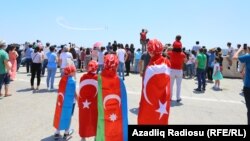 Azərbaycan və Türkiyə bayrağı geyinən uşaqlar təyyarə şousuna baxırlar