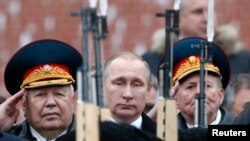 Russian President Vladimir Putin watches honor guards pass as he attends a wreath-laying ceremony to mark the Defender of the Fatherland Day at the Tomb of the Unknown Soldier by the Kremlin wall in central Moscow in February 2016.