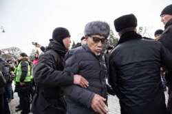 Силовики задерживают пожилого мужчину в Алматы во время митинга. 22 февраля 2020 года.