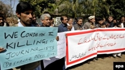 FILE: Pakistani journalists hold placards during a protest against the killing of fellow journalist, in Peshawar, March 2013.