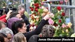 People gather at the crime scene near Ahlens department store in central Stockholm on April 8.