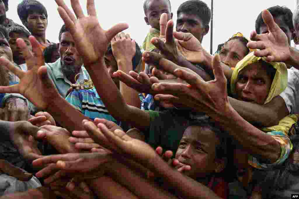 Refugees reach for food aid at the Kutupalong refugee camp in Ukhiya, near the Bangladesh-Burma border.