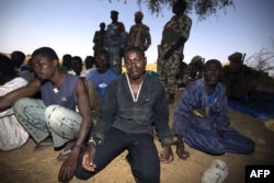 Малийские солдаты охраняют пленных экстремистов. Берег реки Нигер, март 2103 года