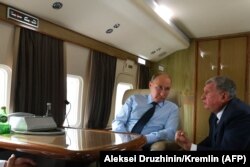 Vladimir Putin dhe Igor Sechin duke biseduar teksa qëndrojnë brenda një avioni privat. Gusht, 2018.