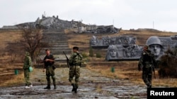 Pro-Russian separatists walk toward a destroyed war memorial at Saur-Mohyla, a hill east of the city of Donetsk, on August 28.
