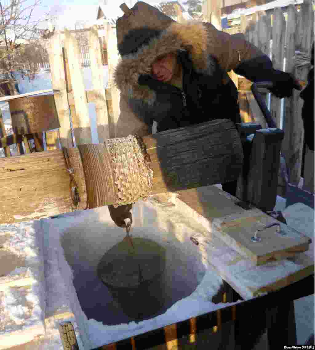 A resident of Temirtau, Kazakhstan, draws water from a partially frozen well.
