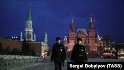 Police officers patrol a deserted Red Square.