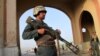 FILE: An Afghan policeman keeps watch at a check point in the city of Ghazni, capital of the province with the same name.