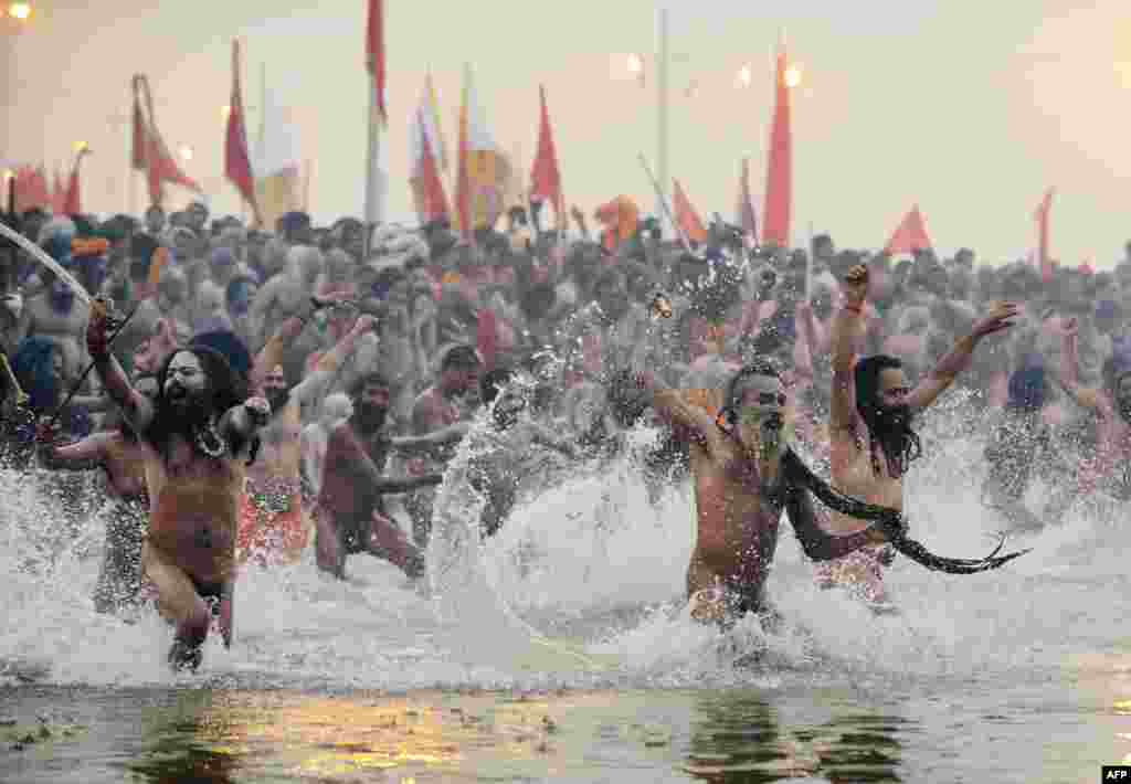 Hundreds of thousands of Hindu pilgrims led by naked, ash-covered holy men stream into the sacred Ganges River at the start of the world's biggest religious festival. The Kumbh Mela in the Indian town of Allahabad will see up to 100 million worshippers gather over the next 55 days to take a ritual bath in the holy waters, believed to cleanse sins and bestow blessings. Before daybreak on January 14, a day chosen by astrologers as auspicious, hundreds of gurus, some brandishing swords and tridents, ran into the swirling and freezing waters for the first bath, signaling the start of events. (AFP/Roberto Schmidt)