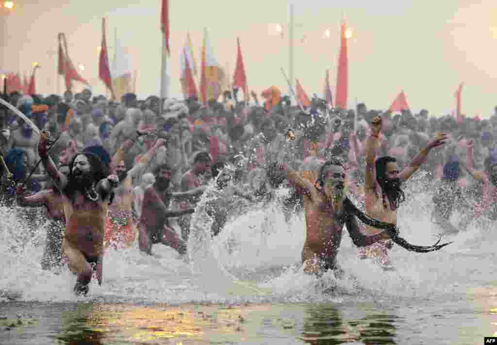 Hundreds of thousands of Hindu pilgrims led by naked, ash-covered holy men stream into the sacred Ganges River at the start of the world&#39;s biggest religious festival. The Kumbh Mela in the Indian town of Allahabad will see up to 100 million worshippers gather over the next 55 days to take a ritual bath in the holy waters, believed to cleanse sins and bestow blessings. Before daybreak on January 14, a day chosen by astrologers as auspicious, hundreds of gurus, some brandishing swords and tridents, ran into the swirling and freezing waters for the first bath, signaling the start of events. (AFP/Roberto Schmidt)