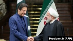 Iranian President Hassan Rouhani (R) shakes hands with Pakistani Prime Minister Imran Khan, a possible mediator between Tehran and Riyadh, in Tehran, October 13, 2019