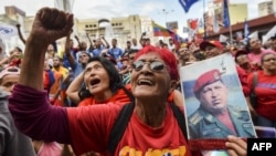 Një mbështetëse e presidentit të Venezuelës, Nicolas Maduro, duke mbajtur një portret të ish presidentit Hugo Chavez, Venezuelë, foto nga arkivi