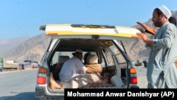 افغانستان: د ننګرهار په مومند دره کې په ۱۱م سپټمبر ۲۰۱۸ ز کال د ځانمرګي برید یو وژل شوی تن وړل کېږي.