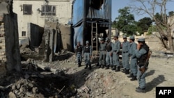 Afghan policemen inspect the site of a seemingly botched suicide attack in Kabul on May 25.