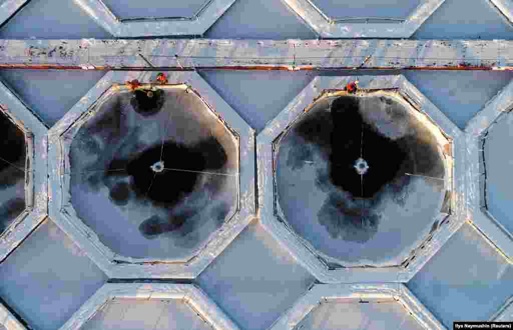 An aerial view shows employees working on fish ponds for trout and sturgeon at a fish farm on the frozen Yenisei River near the Siberian village of Primorsk in the Krasnoyarsk region of Russia. (Reuters/Ilya Naymushin)
