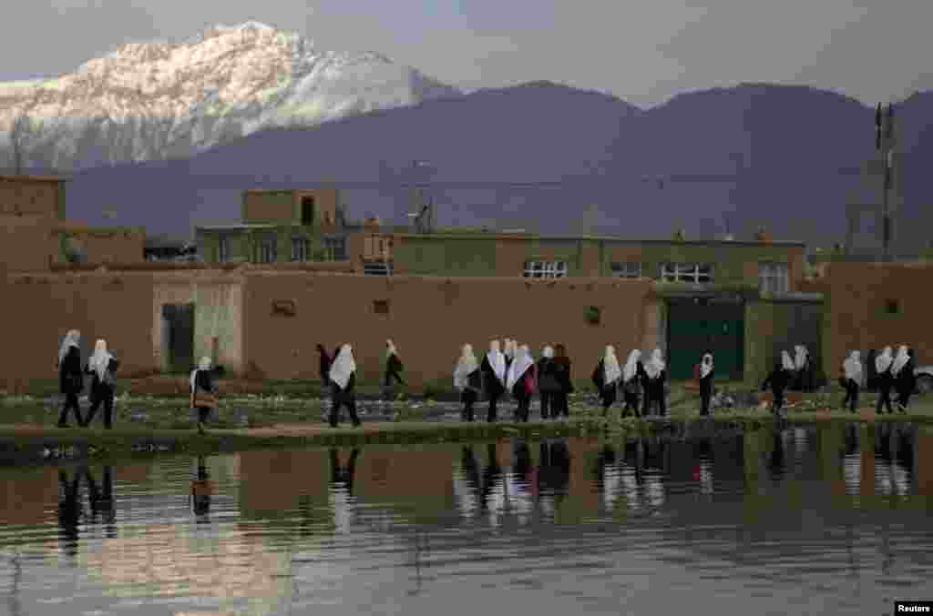 Afghan students walk along a lake as they head home in Kabul. (Reuters/Mohammad Ismail)