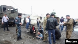Police working at the scene of a suicide bombing in Chechnya's Sunzhen district. Three police officers were killed and four injured in the blast.