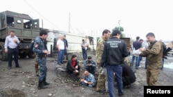 Police working at the scene of a suicide bombing in Chechnya's Sunzhen district. Three police officers were killed and four injured in the blast. 