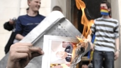 Un protestatar pe scările Președinției, pe 7 aprilie 2009, ținând o fotografie în flăcări a președintelui comunist de atunci, Vladimir Voronin 