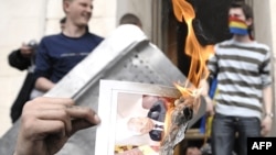 Un protestatar pe scările Președinției, pe 7 aprilie 2009, ținând o fotografie în flăcări a președintelui comunist de atunci, Vladimir Voronin 