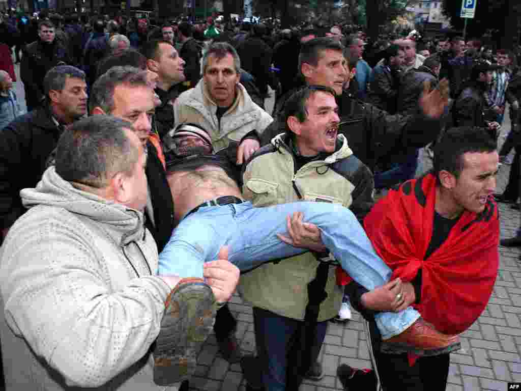 Албански демонстранти го носат телото на мртов човек за време на анти-владините протести во Тирана