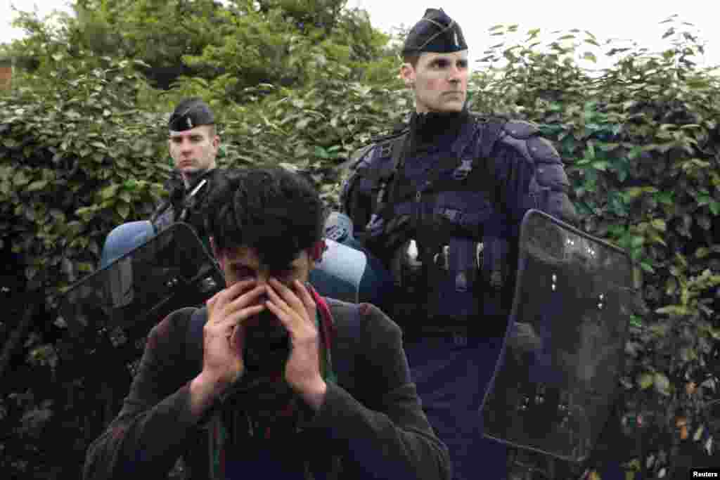 Afganistanski imigrant briše suze dok ga pripadnici francuske policije evakuišu zajedno sa članovima njegove porodice iz improvizovanog kampa u Calaisu, 28. maj, (Reuters/Pascal Rossignol)